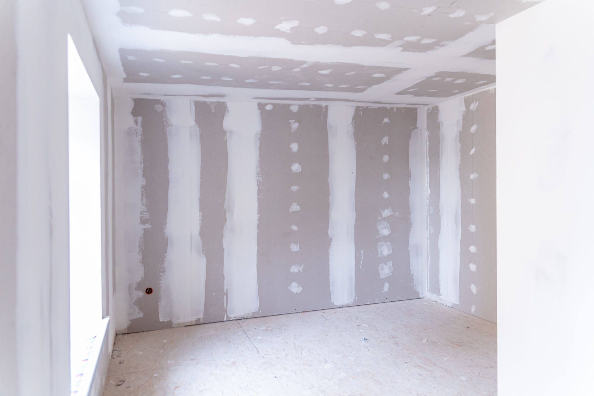 Interior of a house under renovation with drywall installation and joint compound application